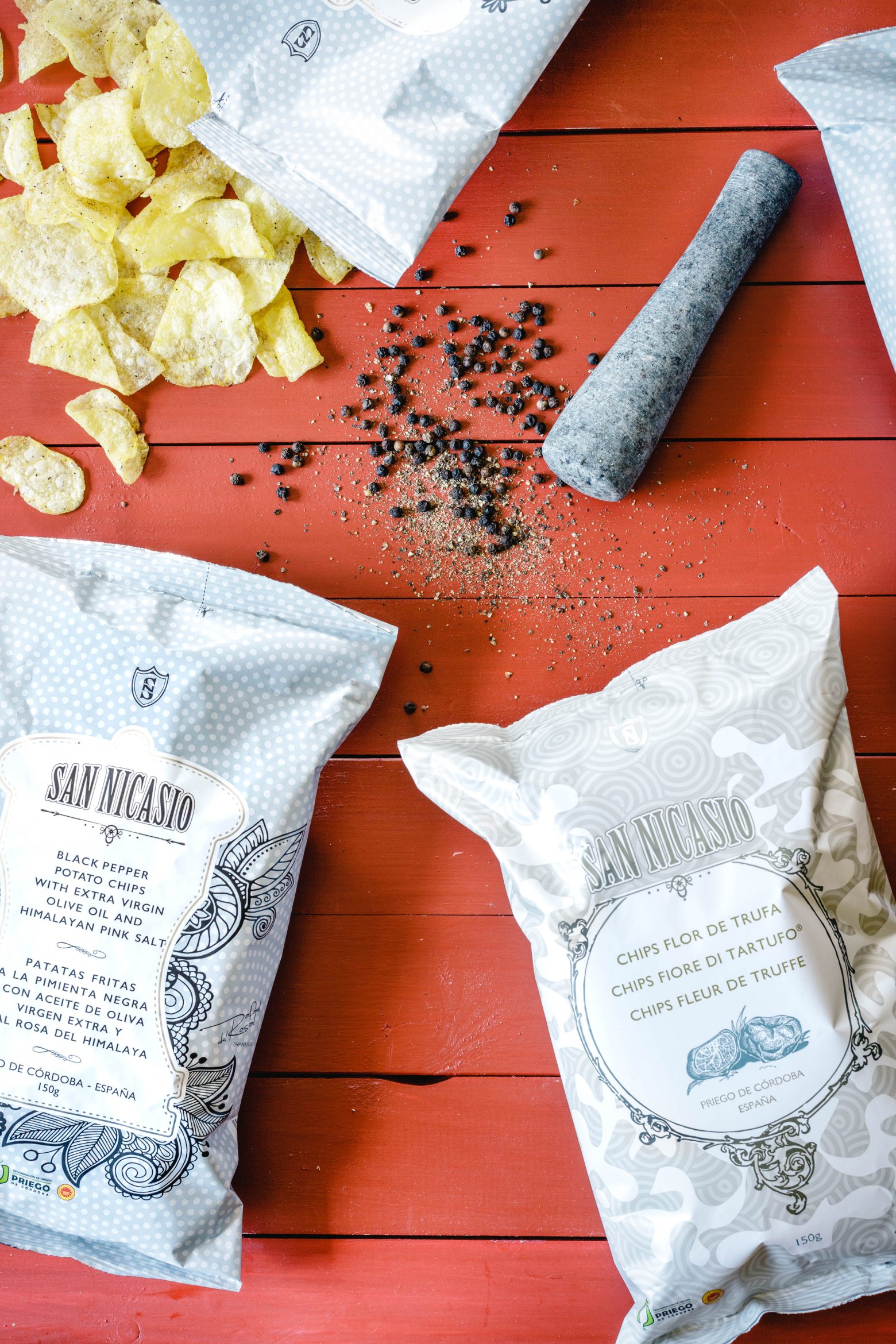 Chips San Nicasio fabriquées avec huile d’olive extra vierge et sel rose de l’Himalaya, accompagnées de poivre noir.