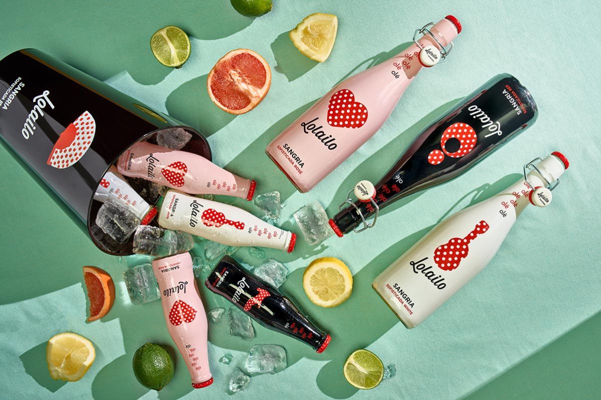 Bouteilles de sangria espagnole Lolailo sur fond coloré avec fruits frais, parfaite pour des apéritifs estivaux.