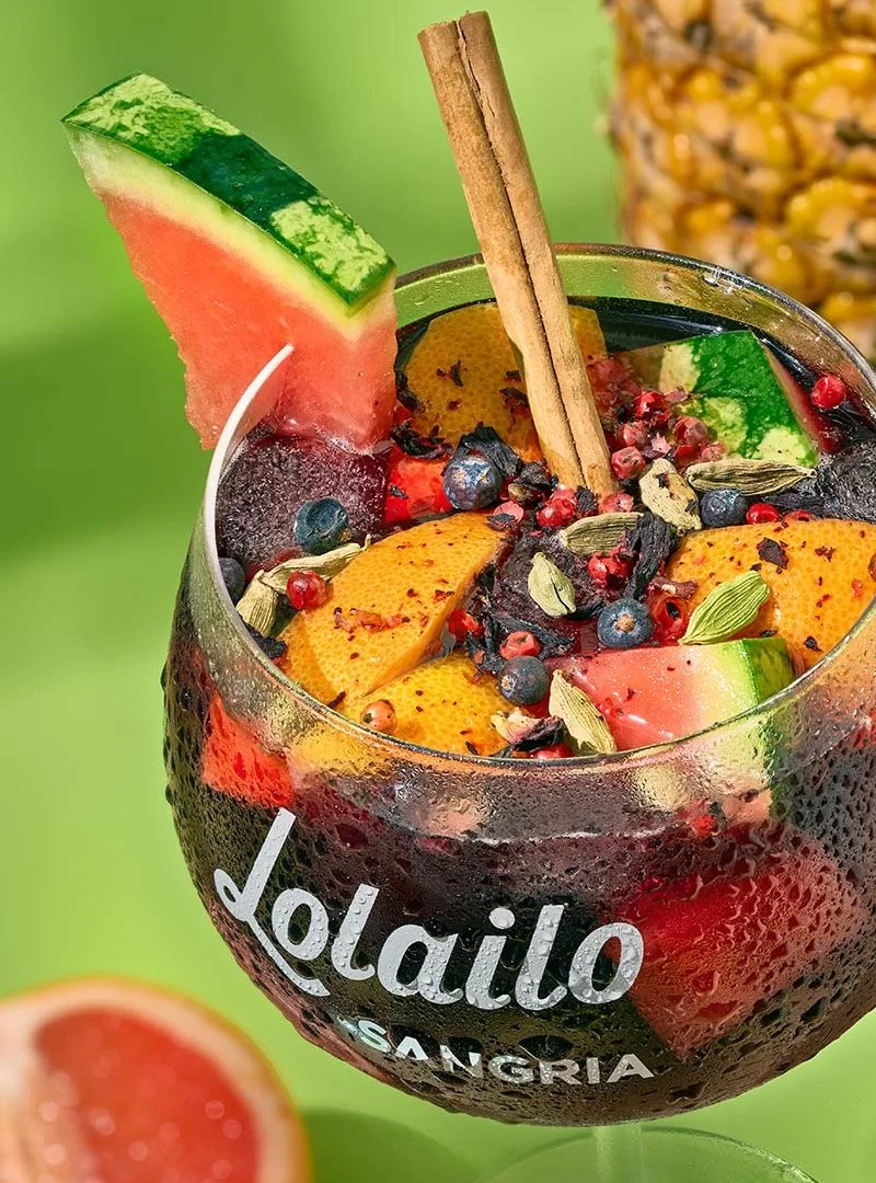 Verre de sangria rouge Lolailo garni de fruits frais et épices, idéal pour un apéritif convivial.