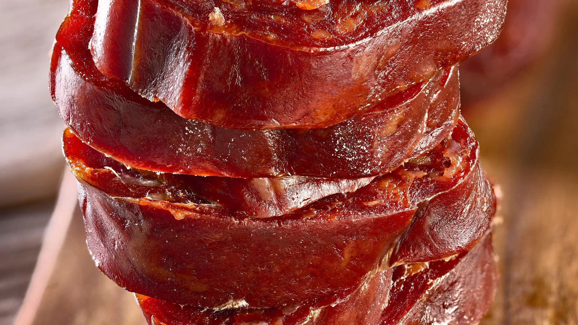 Tranches épaisses de chorizo espagnol artisanal sur une planche en bois.