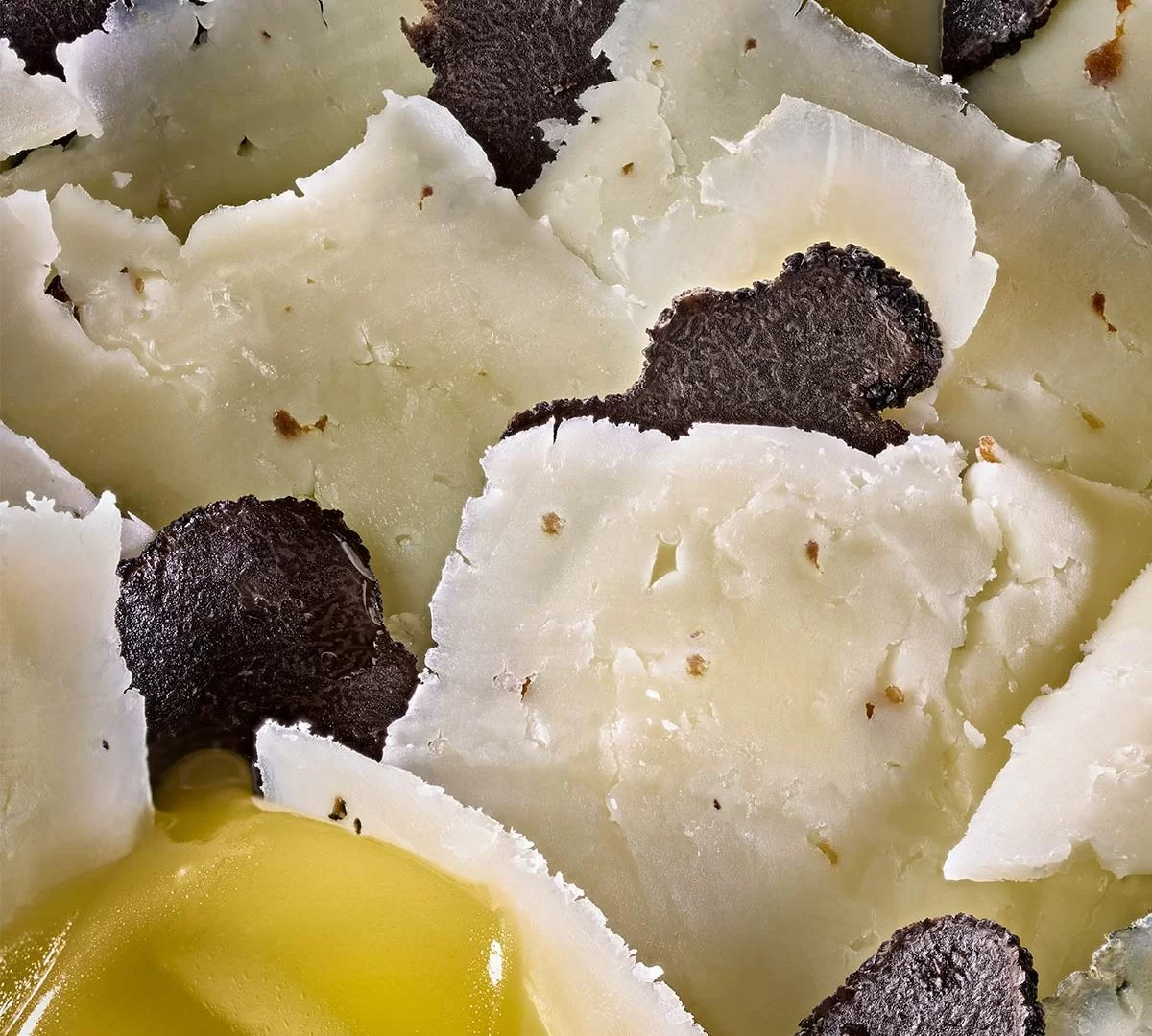Tranches de fromage manchego avec truffes noires et huile d'olive.