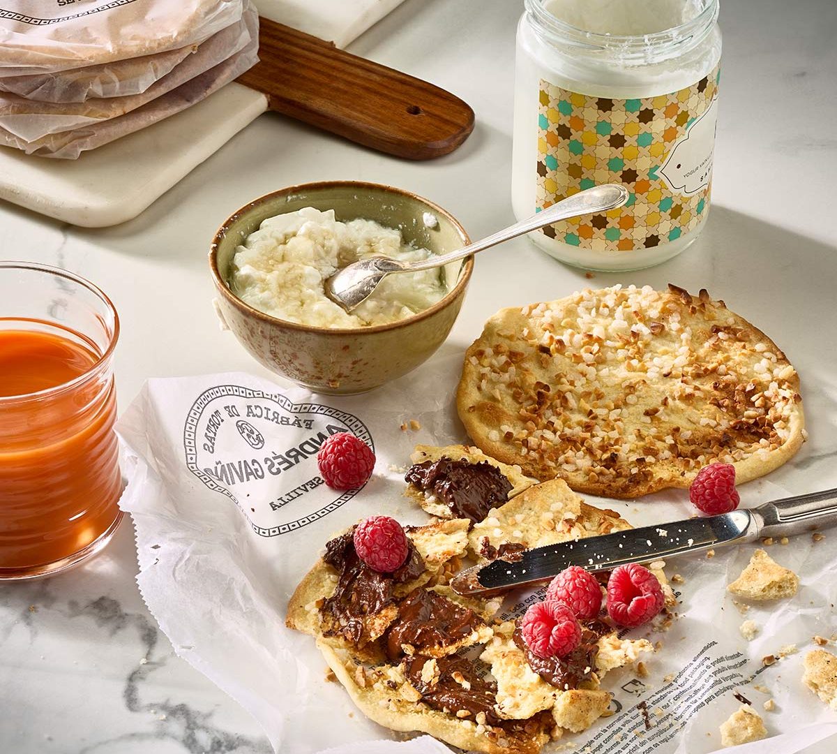Tortas Gaviño présentées avec du yaourt artisanal, des framboises et du chocolat, parfaites pour un goûter gourmand.