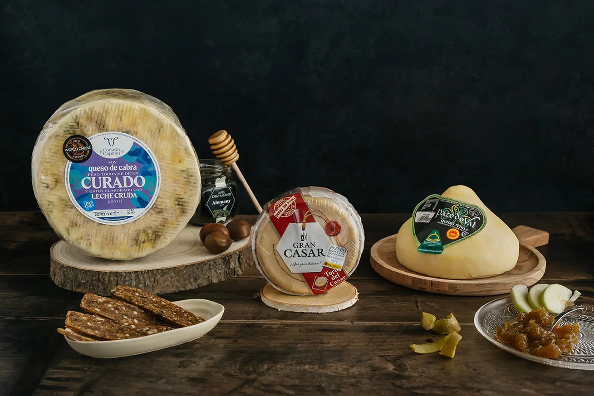 Sélection de fromages espagnols haut de gamme : Tetilla, Torta del Casar et Queso Curado avec accompagnements.