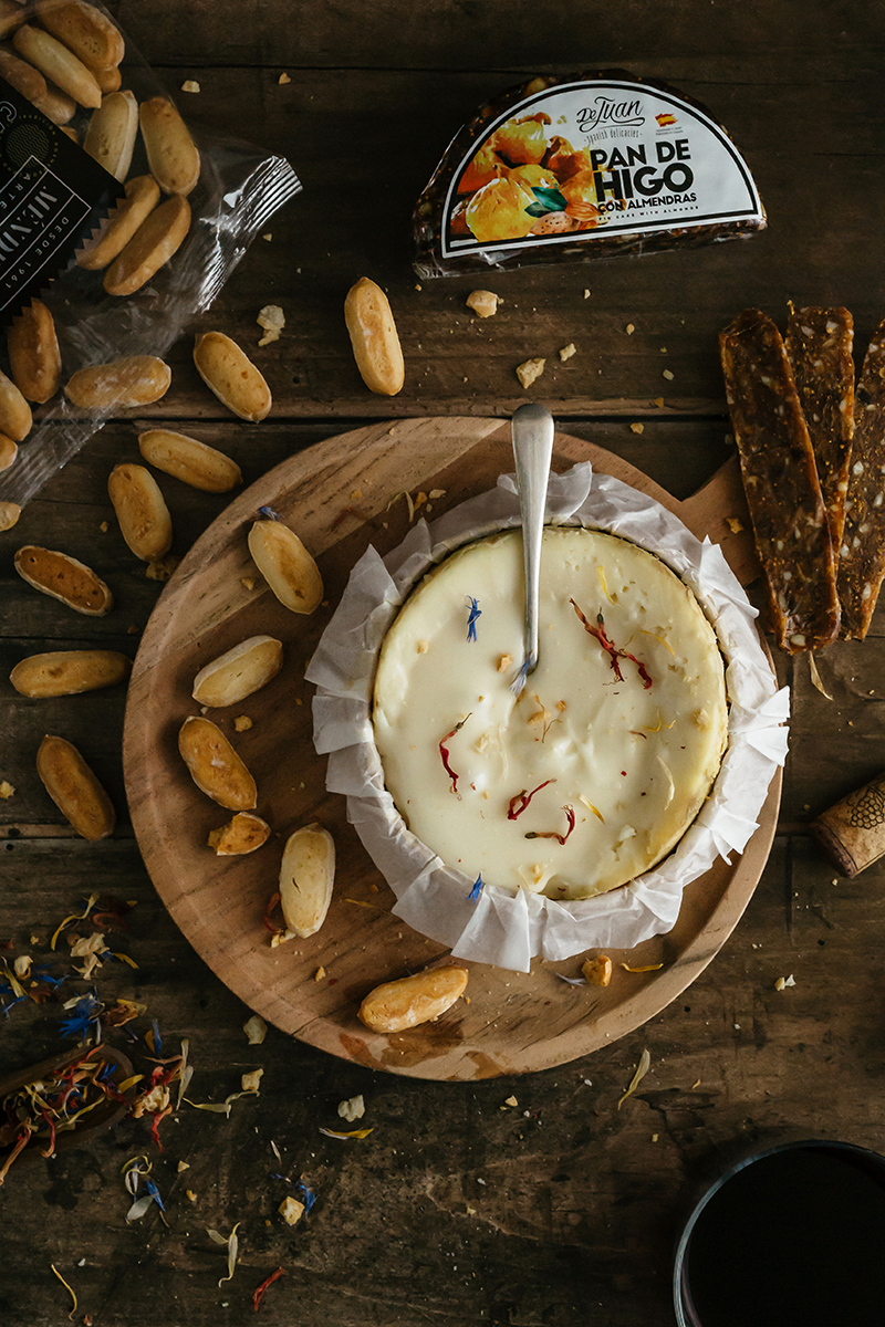 Plateau de Torta del Casar entouré de pan de higo, un mélange espagnol de figues et amandes, et de biscuits artisanaux.