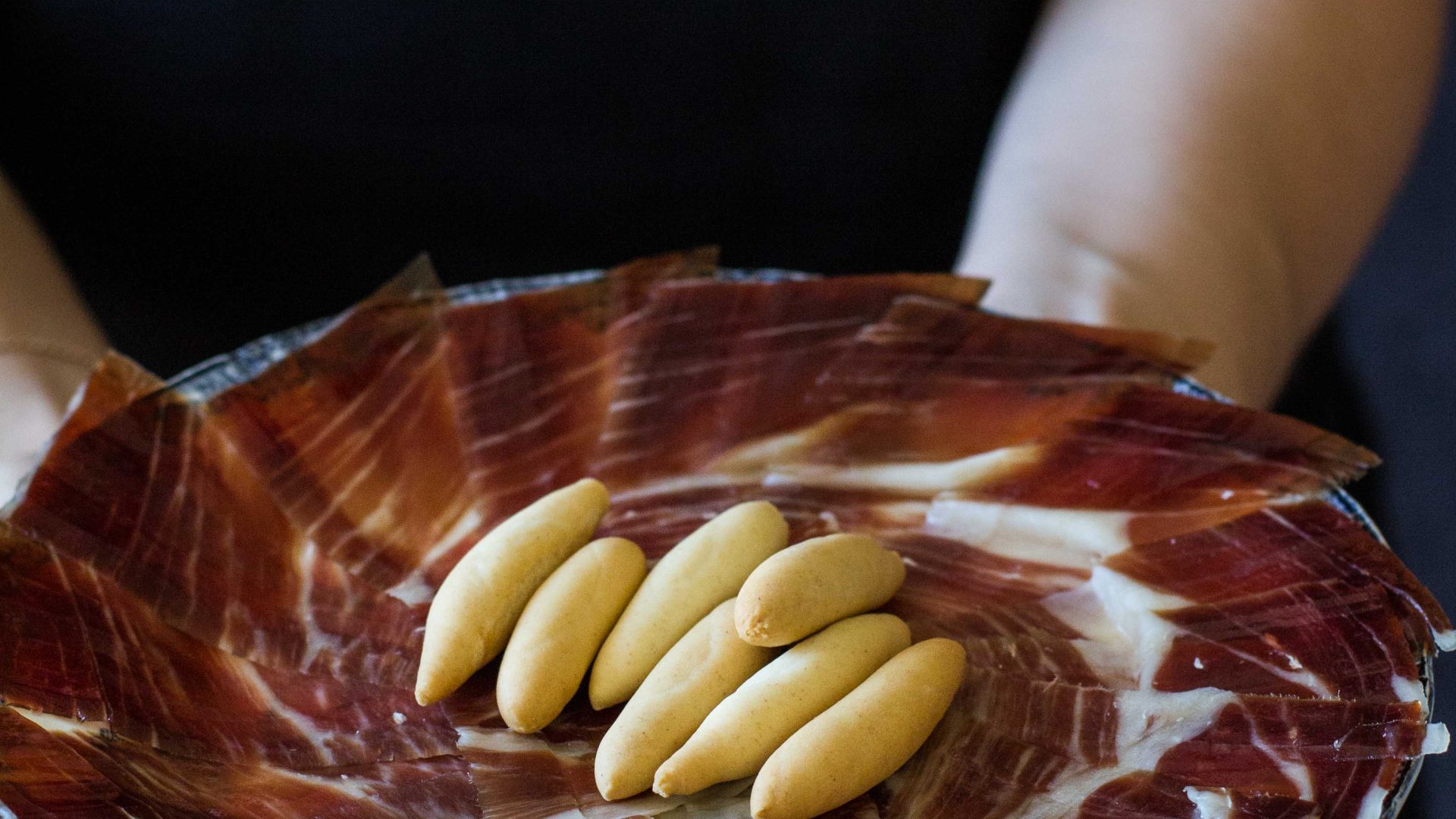 Assiette de jambon Pata Negra avec Picos artisanaux, spécialité espagnole haut de gamme.