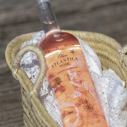 Bouteille de vin rosé espagnol Alma Atlántica Rosé présentée dans un panier en osier, parfaite pour les soirées estivales.
