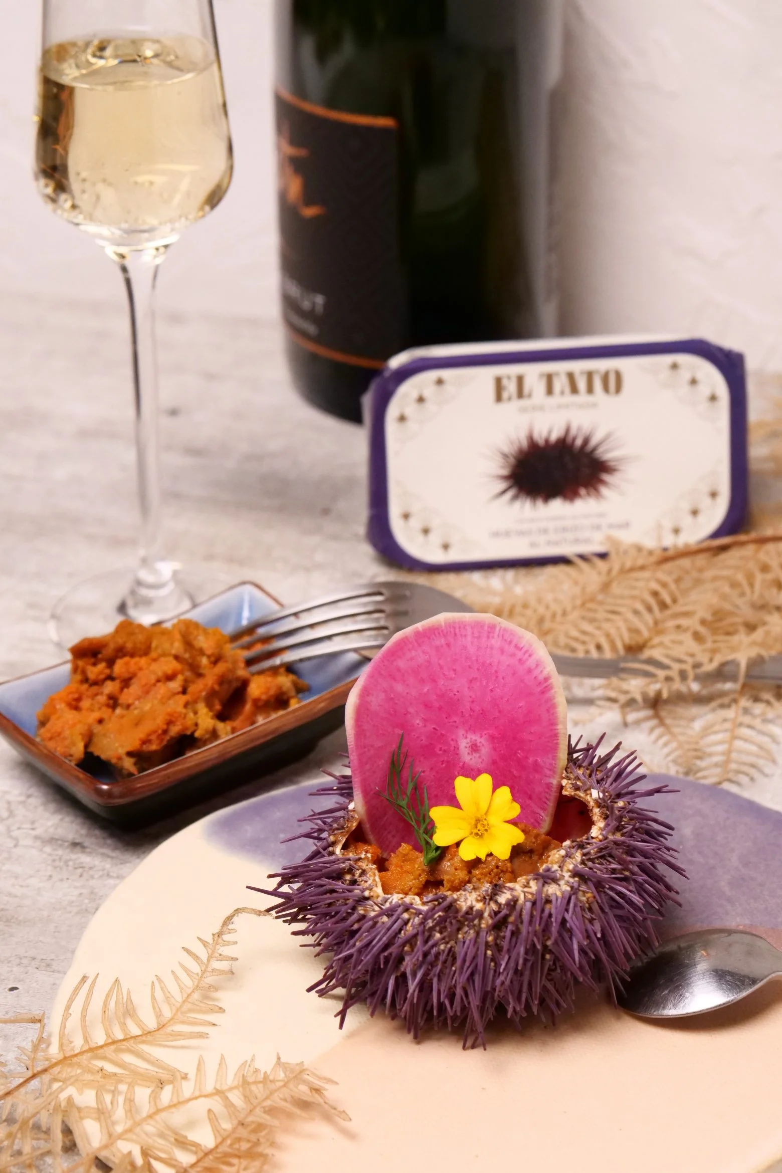 Assiette d’oursins avec corail d’oursin El Tato, accompagné de vin blanc.