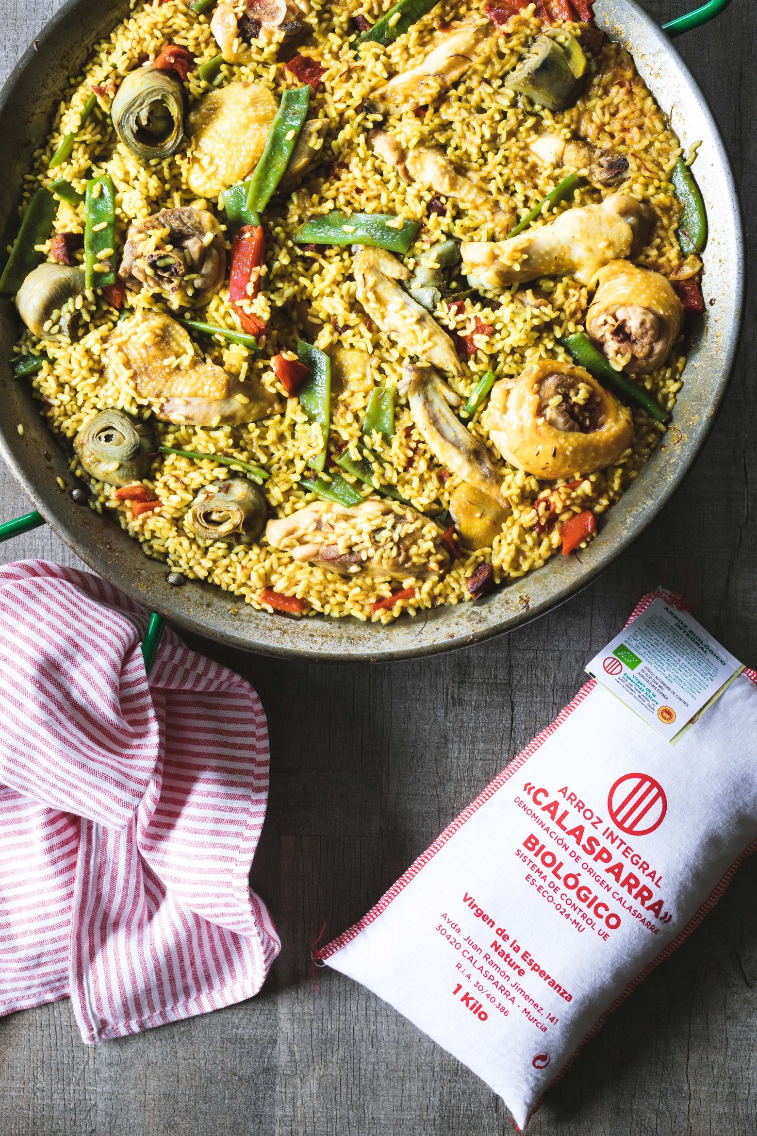 Paella au riz Bomba AOP Valencia et légumes frais, cuisinée dans une poêle traditionnelle.