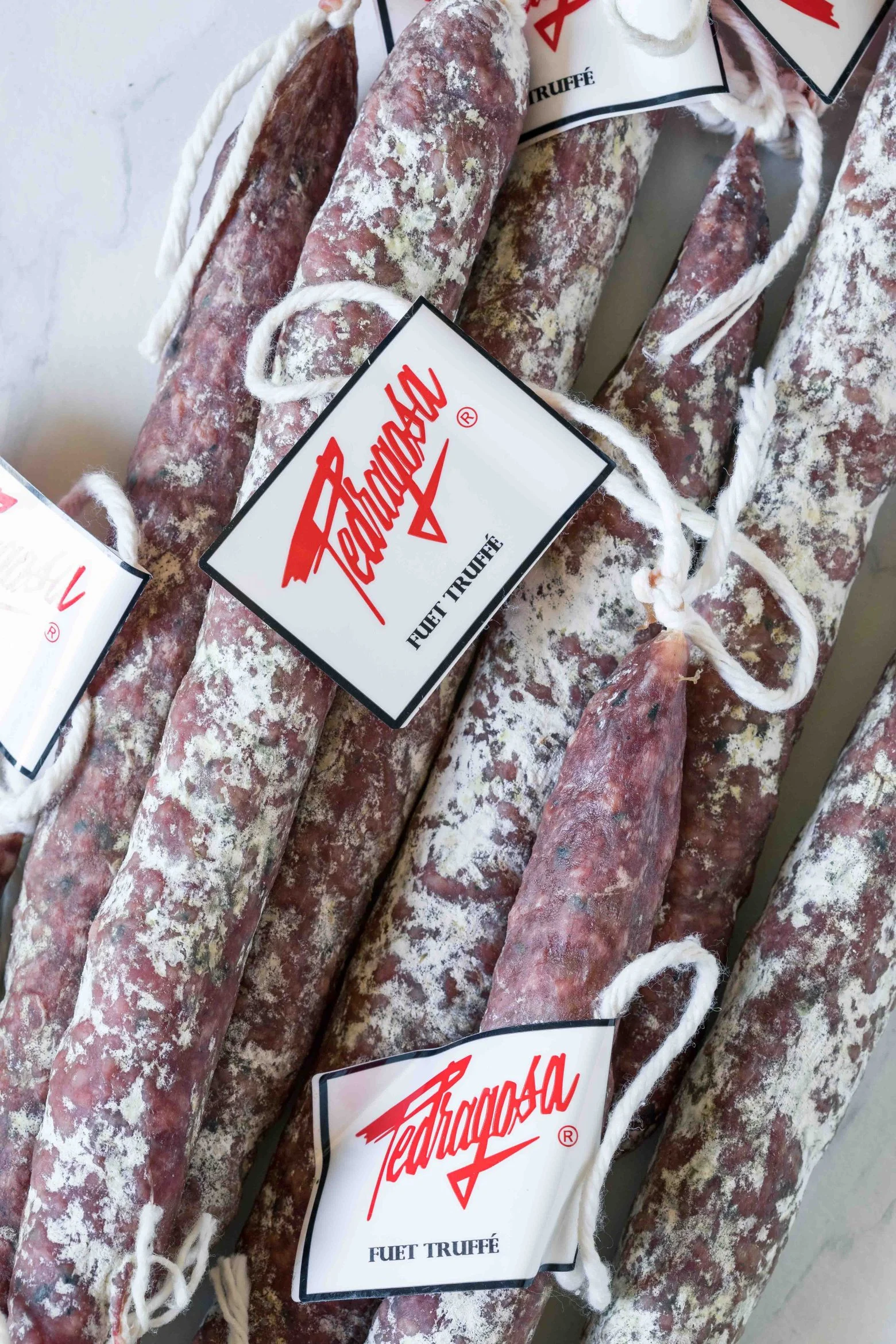 Saucissons truffés catalans artisanaux, emballés avec étiquette Pedragosa.