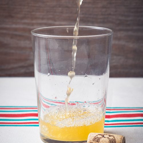 Verre de cidre basque Zapiain avec bulles naturelles lors du service.