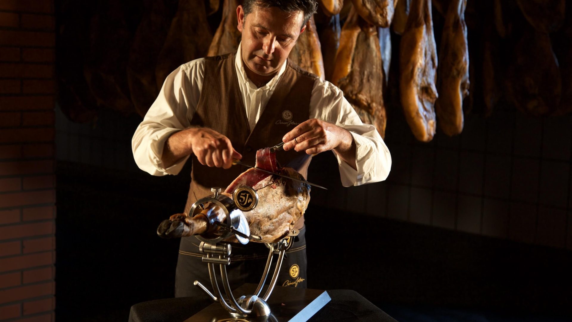 Maestro cortador en pleine découpe de jambon Cinco Jotas