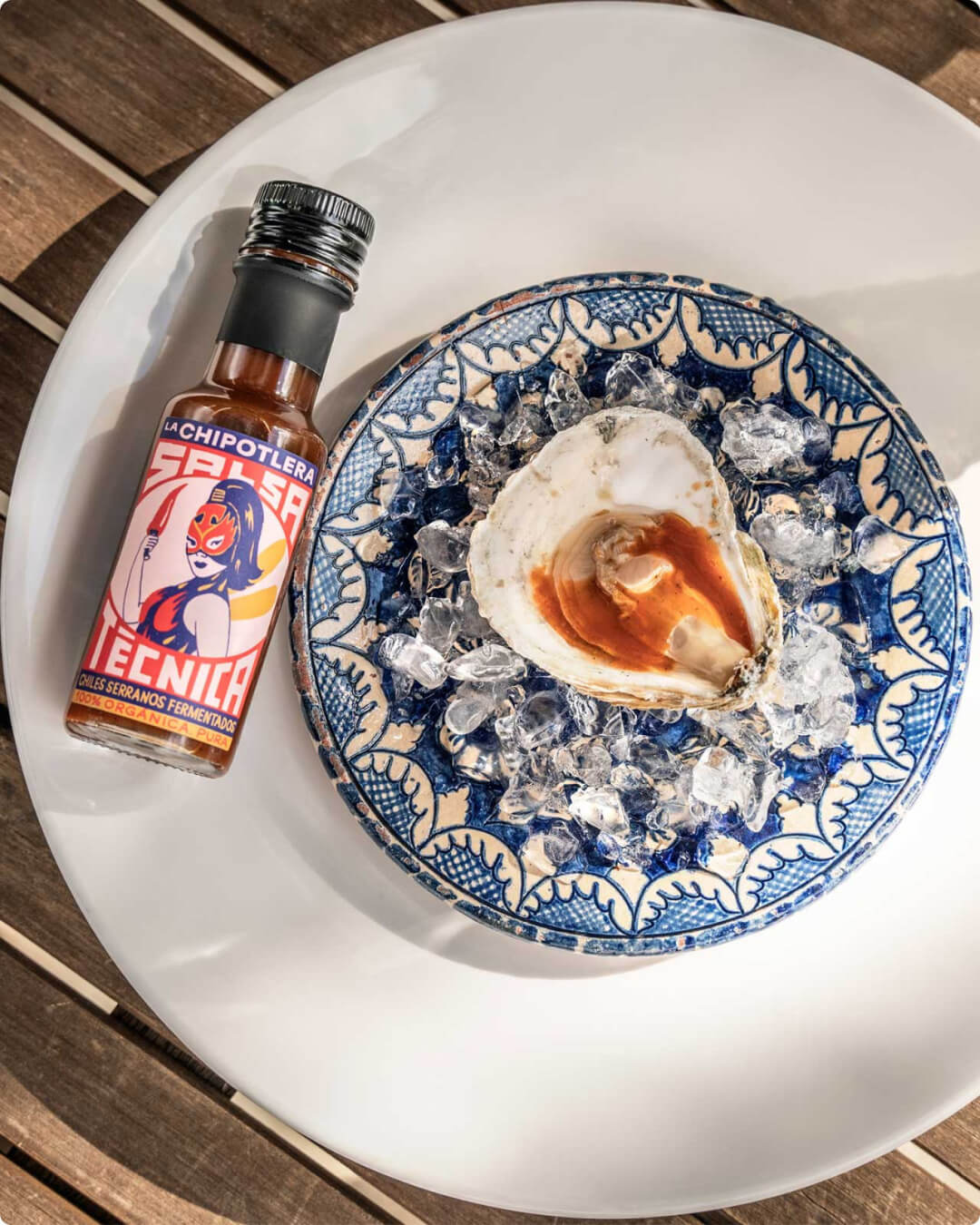 Huître nappée de Salsa Técnica avec bouteille en arrière-plan