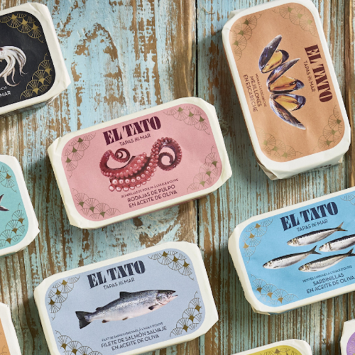 Boîtes colorées de la conserverie El Tato alignées sur un fond en bois