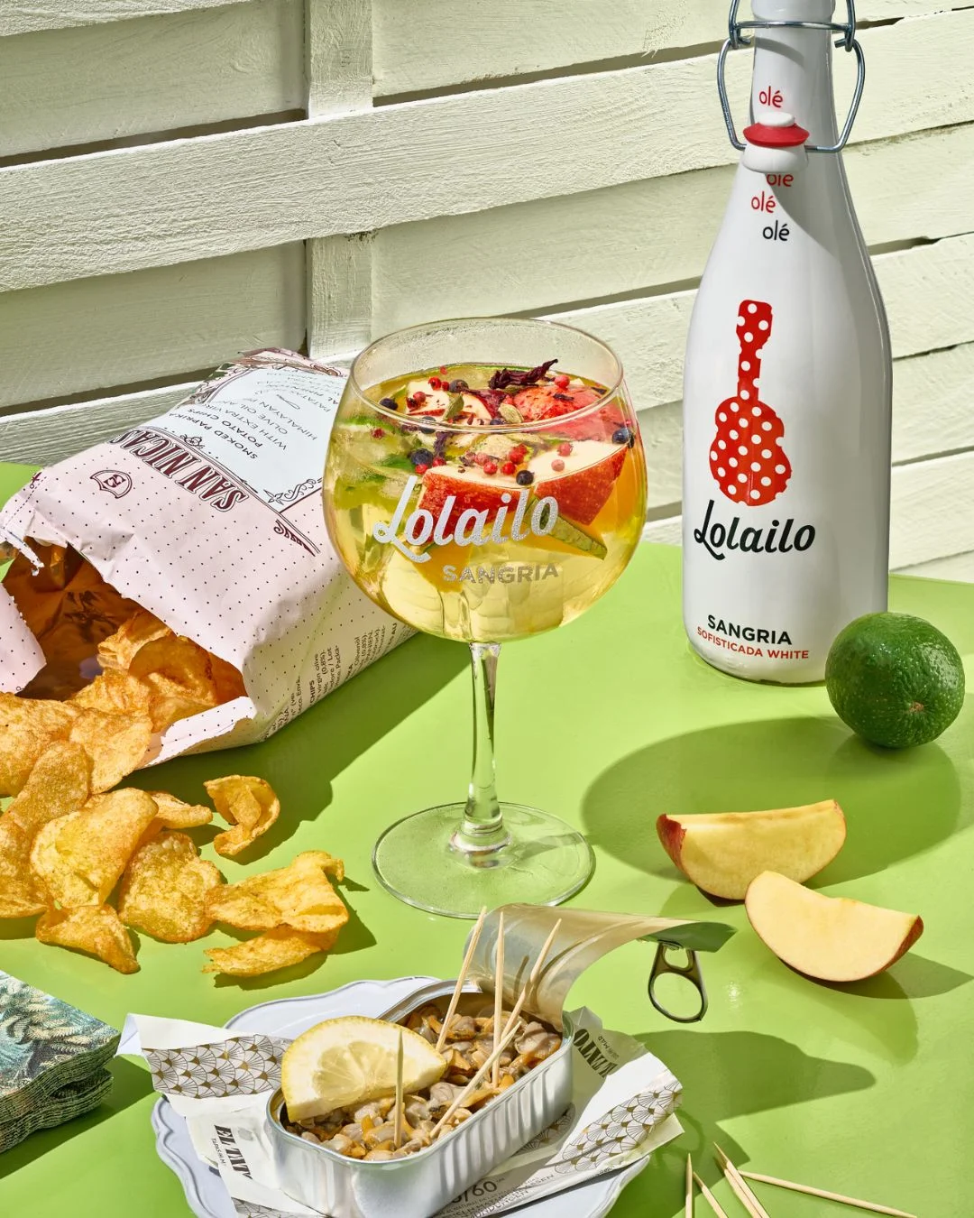 Sangria blanche Lolailo servie avec chips et conserve de fruits de mer