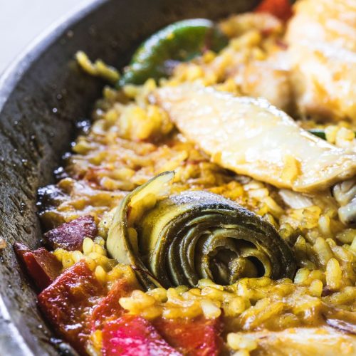 Paëlla espagnole maison dans une poêle, avec riz, artichauts et haricots verts