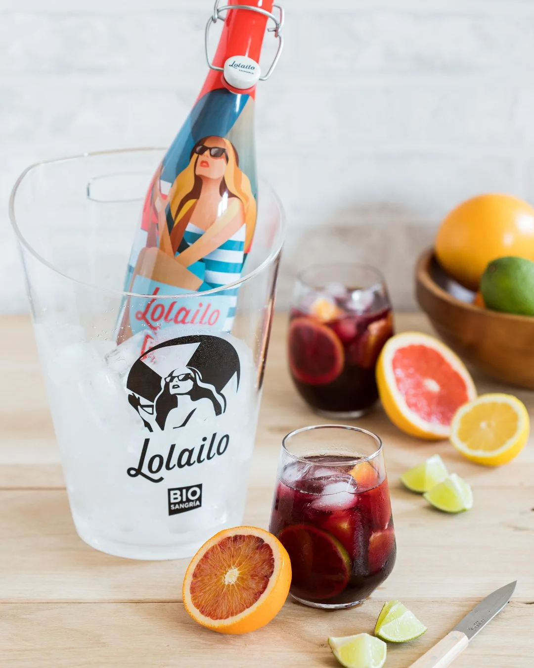 Bouteille de sangria Lolailo bio dans un seau avec glaçons et verres de sangria