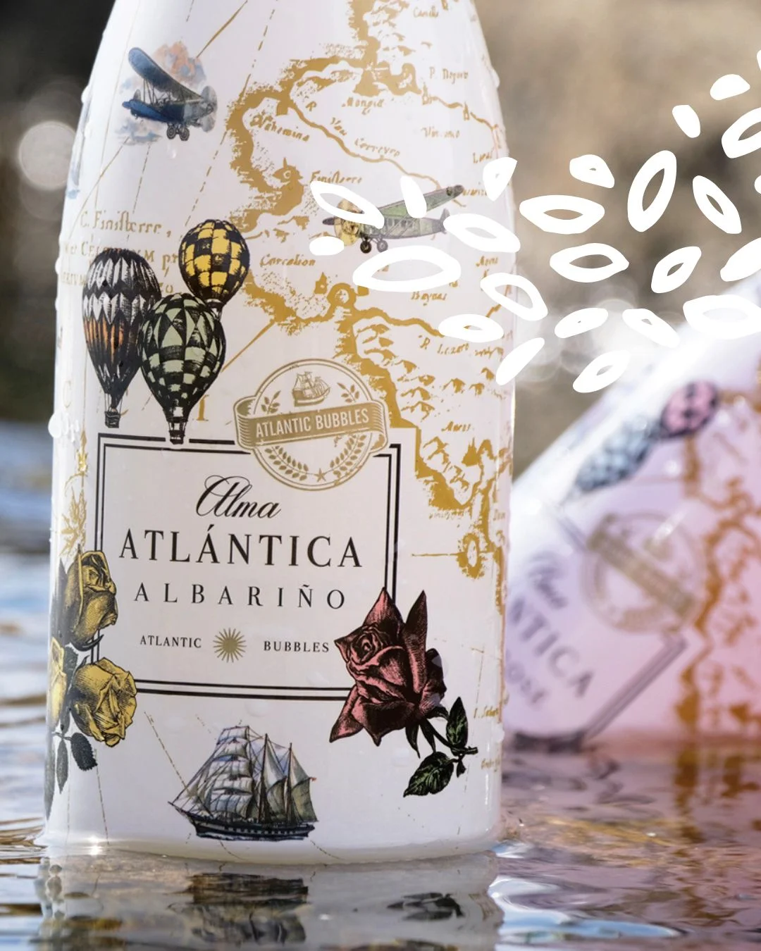Gros plan sur une bouteille Alma Atlántica Albariño avec carte et motifs marins.