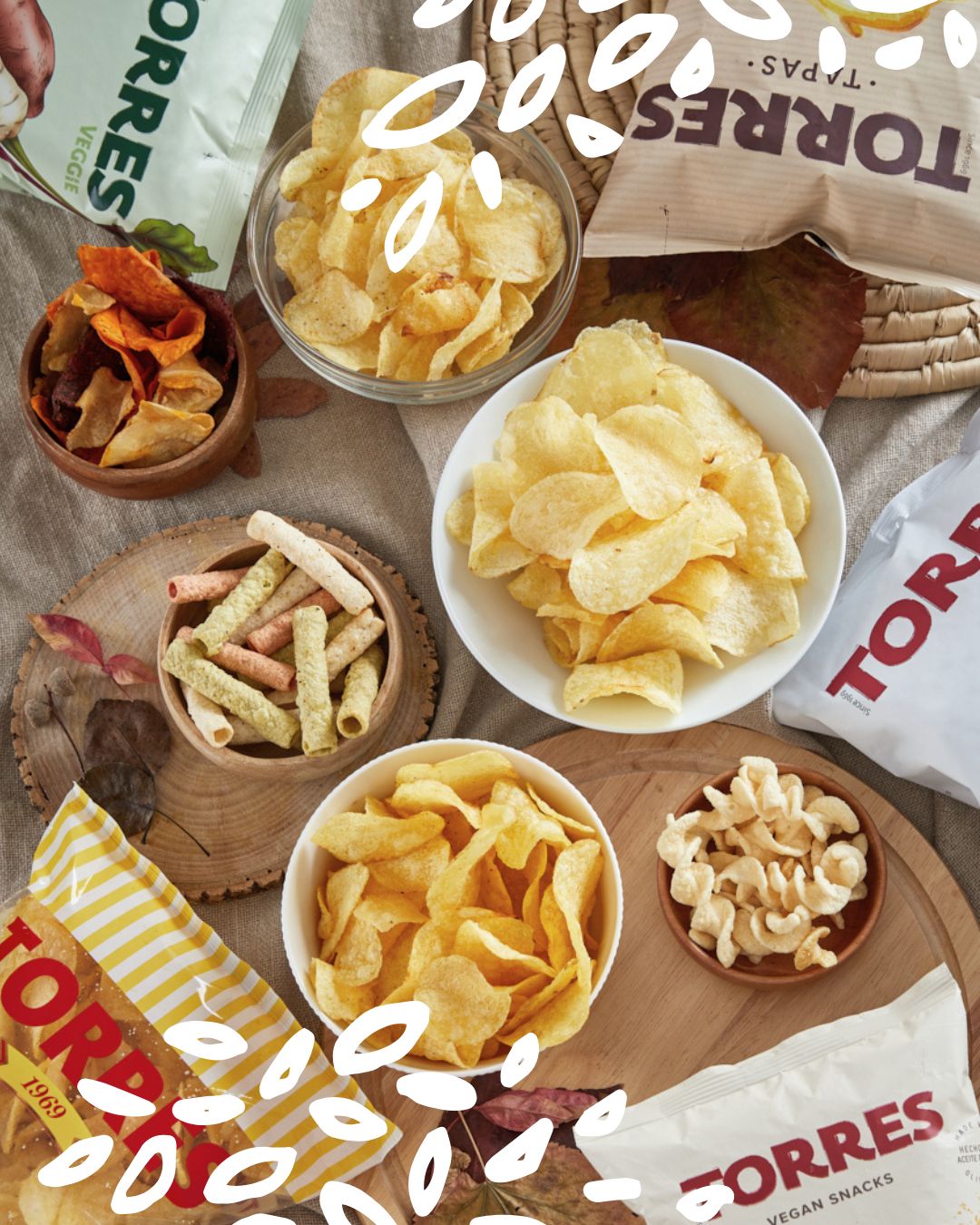 Différents sachets et bols de chips Patatas Torres présentés sur une table pour un apéritif chic.