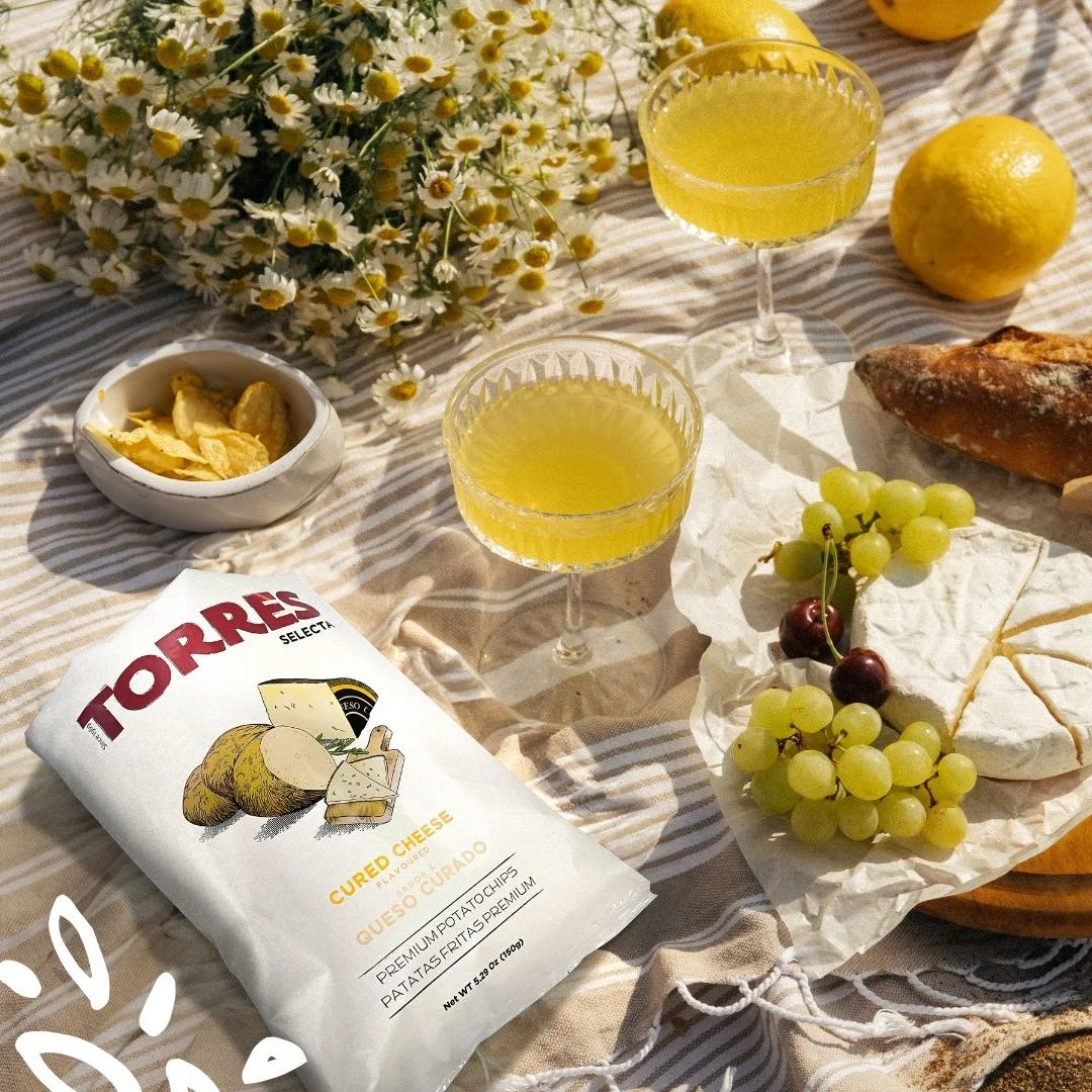 Chips Patatas Torres goût queso curado avec verres de sangria blanche et fruits d’été.