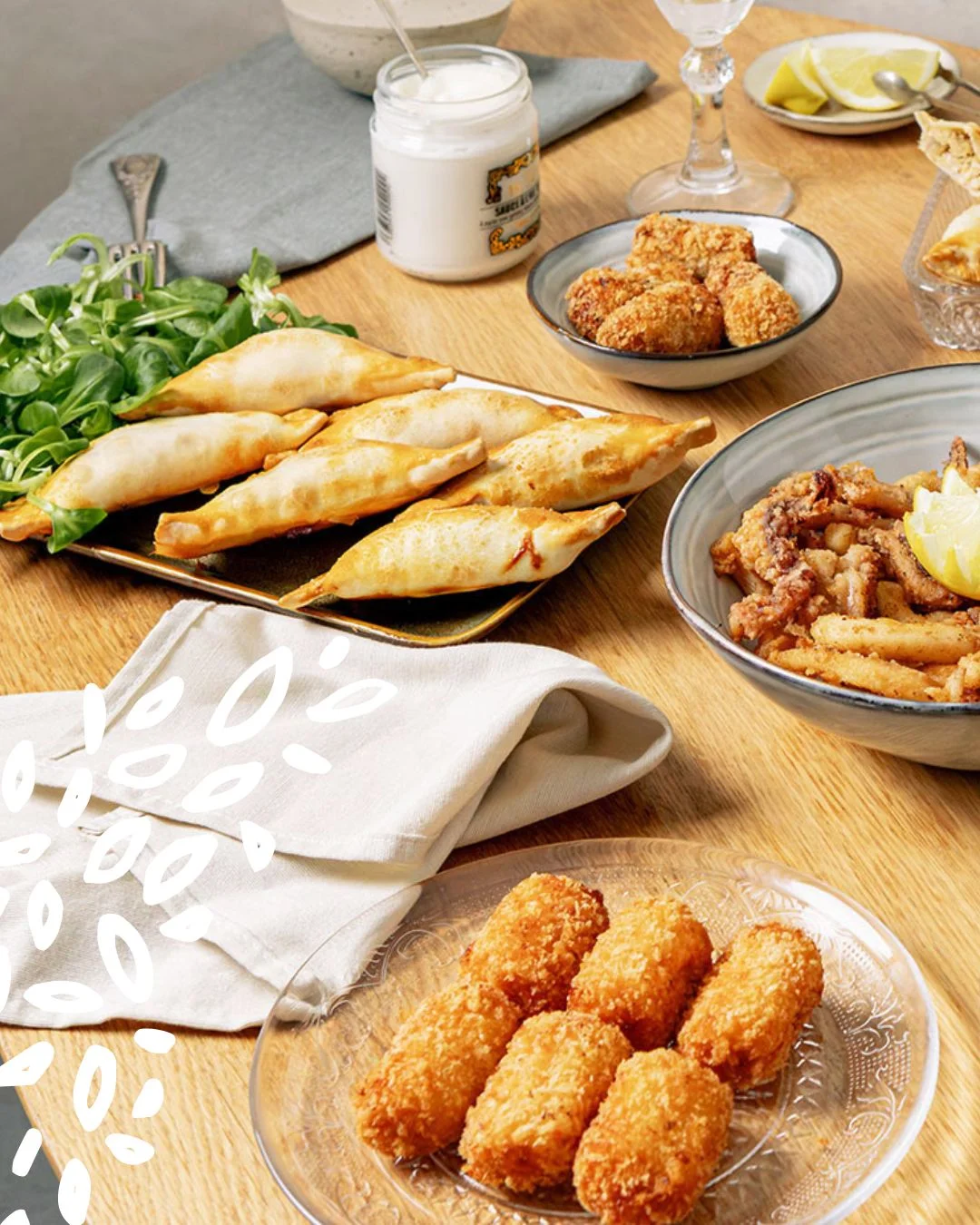 Croquetas panées et empanadillas sur assiette en bois