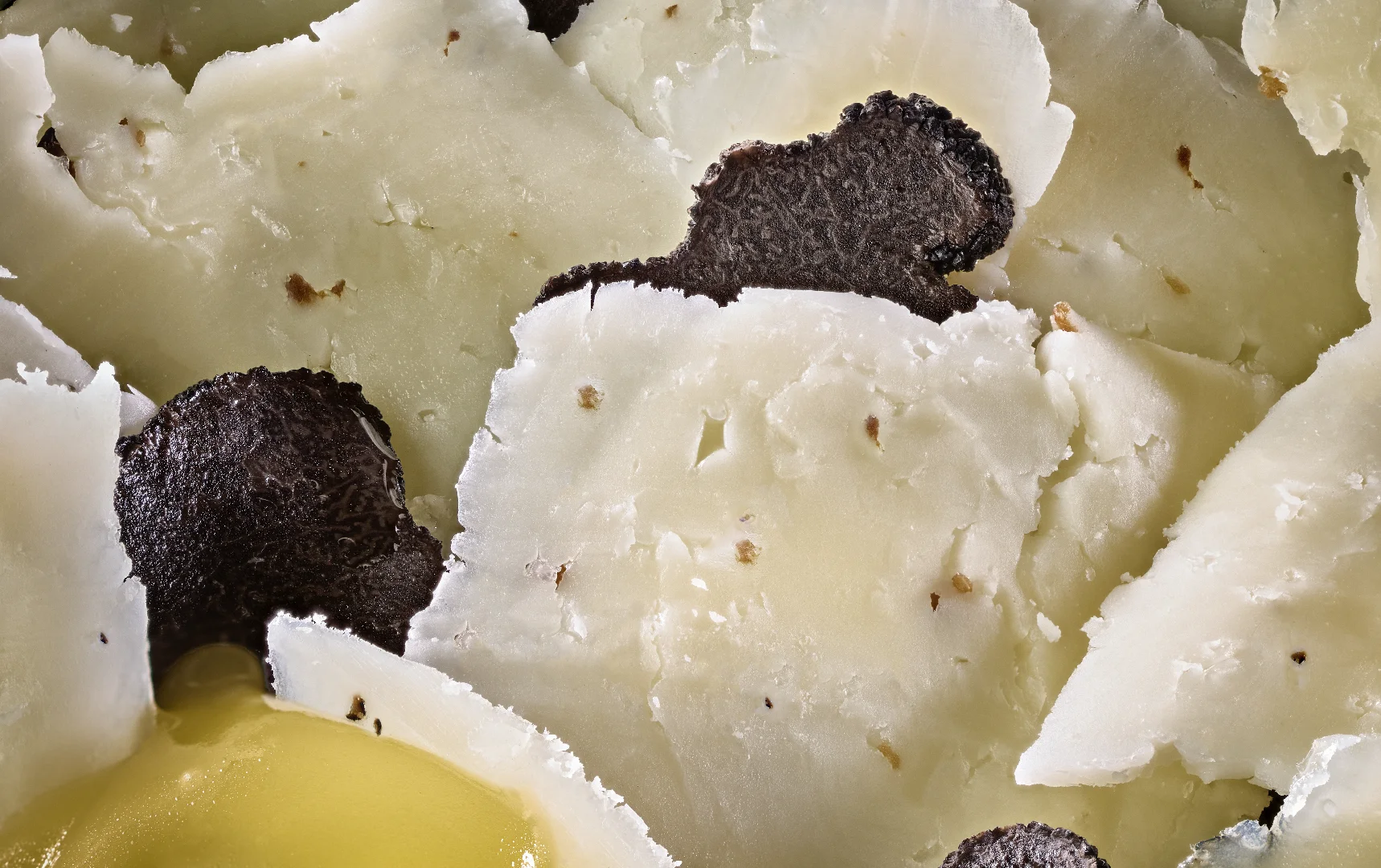 Fromage Manchego affiné avec éclats de truffe noire et huile d’olive.