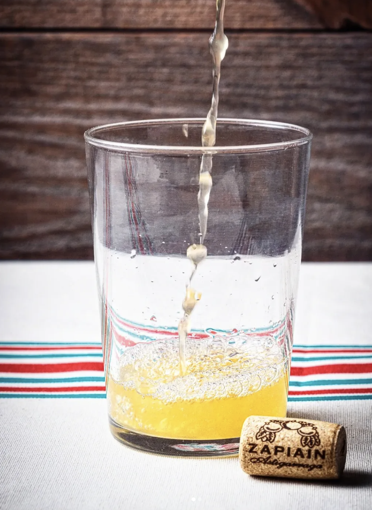 Un verre de cidre Zapiain servi en hauteur selon la tradition basque