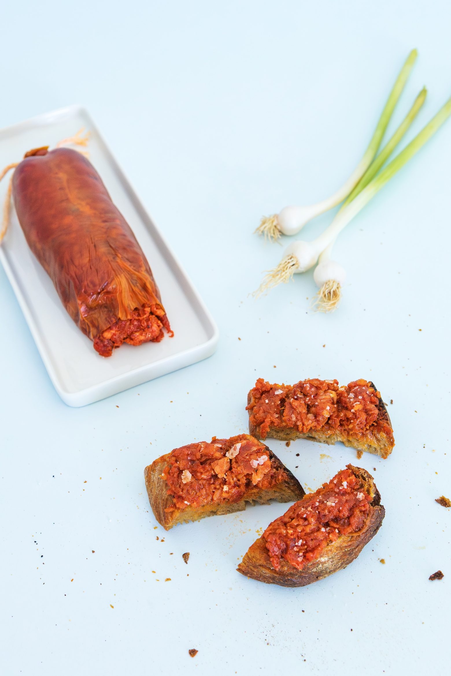 Sobrasada de Mallorca tartinée sur pain grillé, ail frais en arrière-plan
