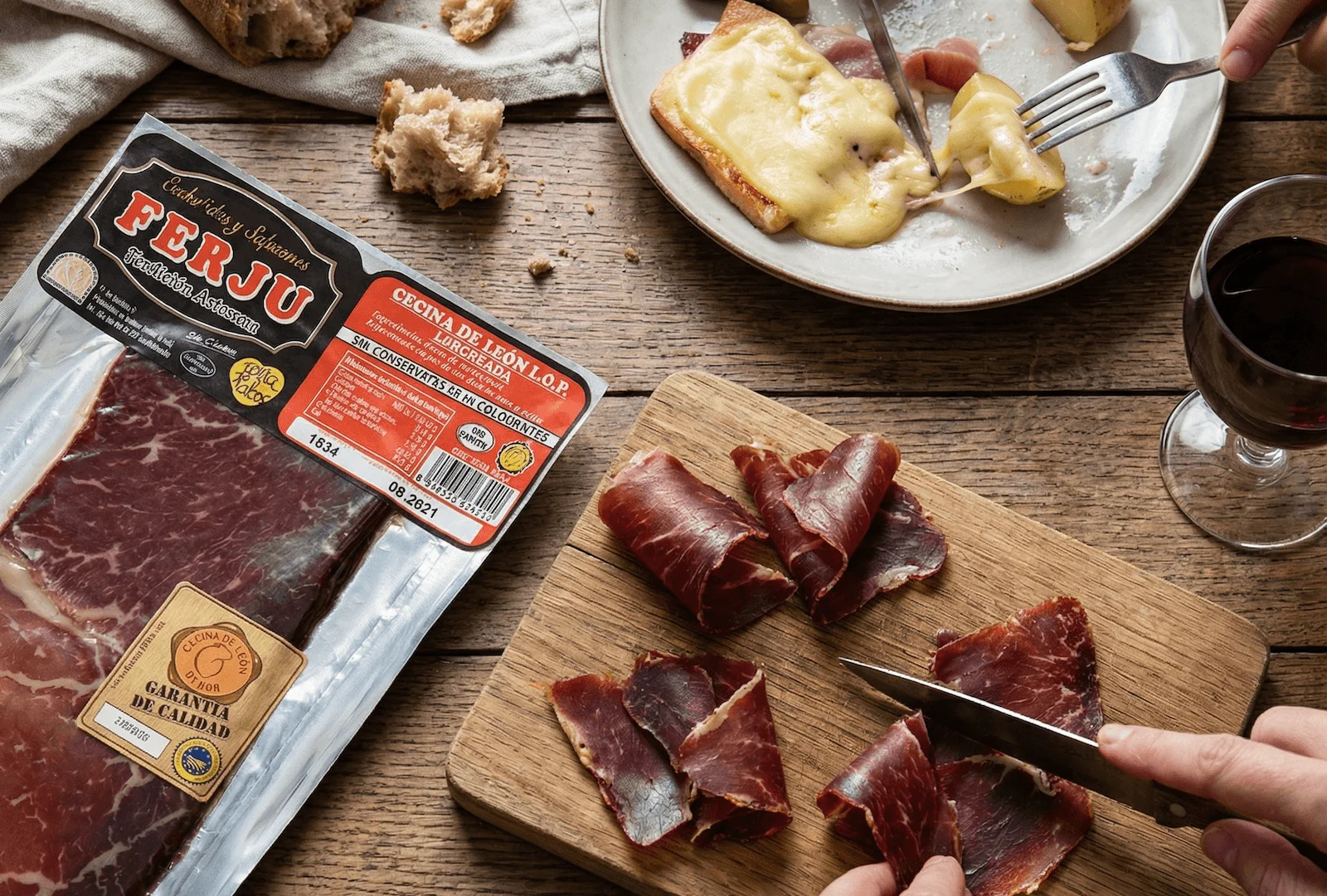 Cecina de León I.G.P. FERJU tranchée finement, servie avec pain, vin rouge et raclette ibérique