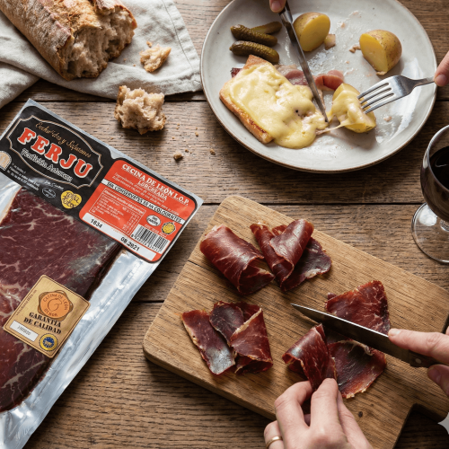 Cecina de León I.G.P. FERJU tranchée finement, servie avec pain, vin rouge et raclette ibérique