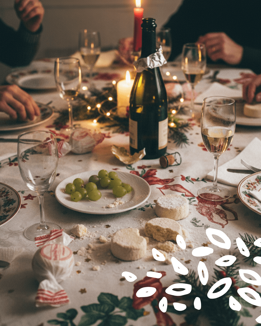 Polvorones disposés sur une nappe de Noël, avec verres, bougie et raisins
