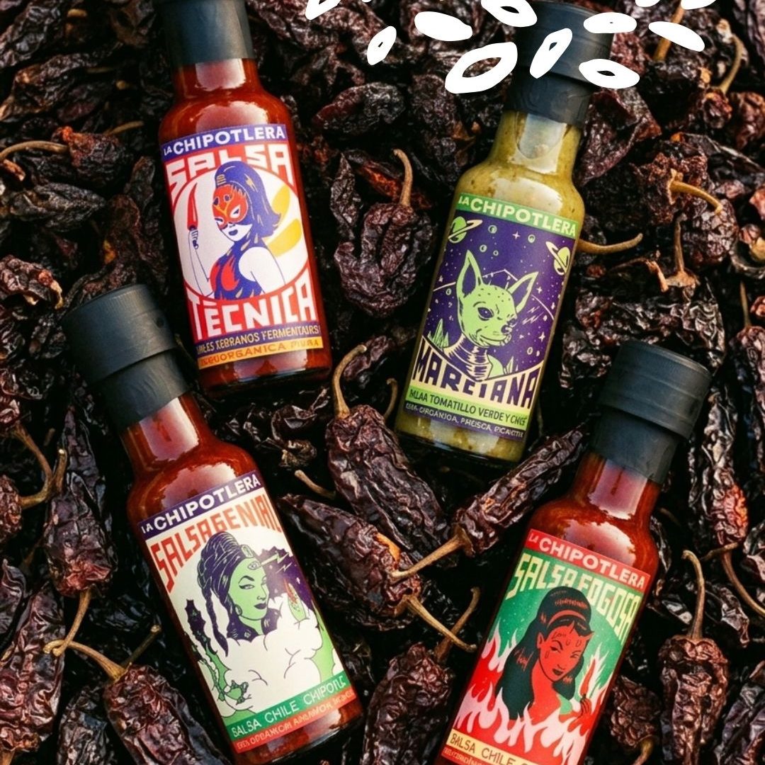 Bouteilles de sauces bio La Chipotlera, dont Marciana salsa verde, posées sur un lit de piments séchés