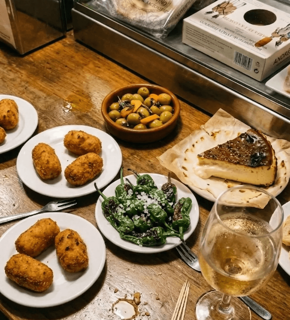 Assortiment de tapas Cofrit sur comptoir avec croquetas, pimientos, cheesecake basque et olives