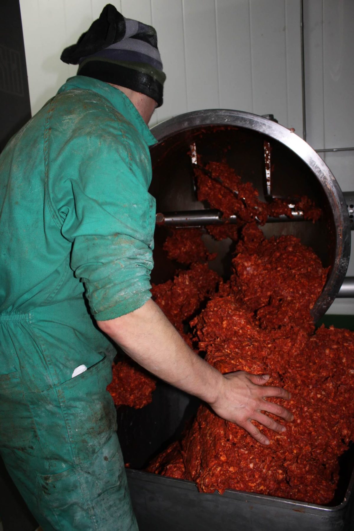 Préparation artisanale du morcón ibérique avec viande de porc ibérique et pimentón de la Vera.