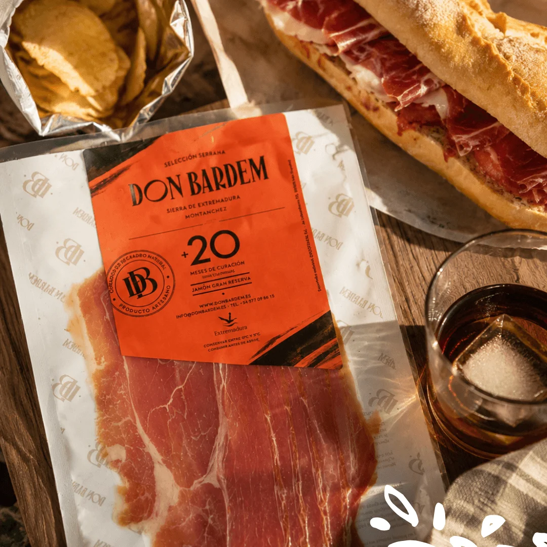 Serrano Gran Reserva Don Bardem prétranché, affiné plus de 20 mois à Montánchez, présenté avec un sandwich gourmet.