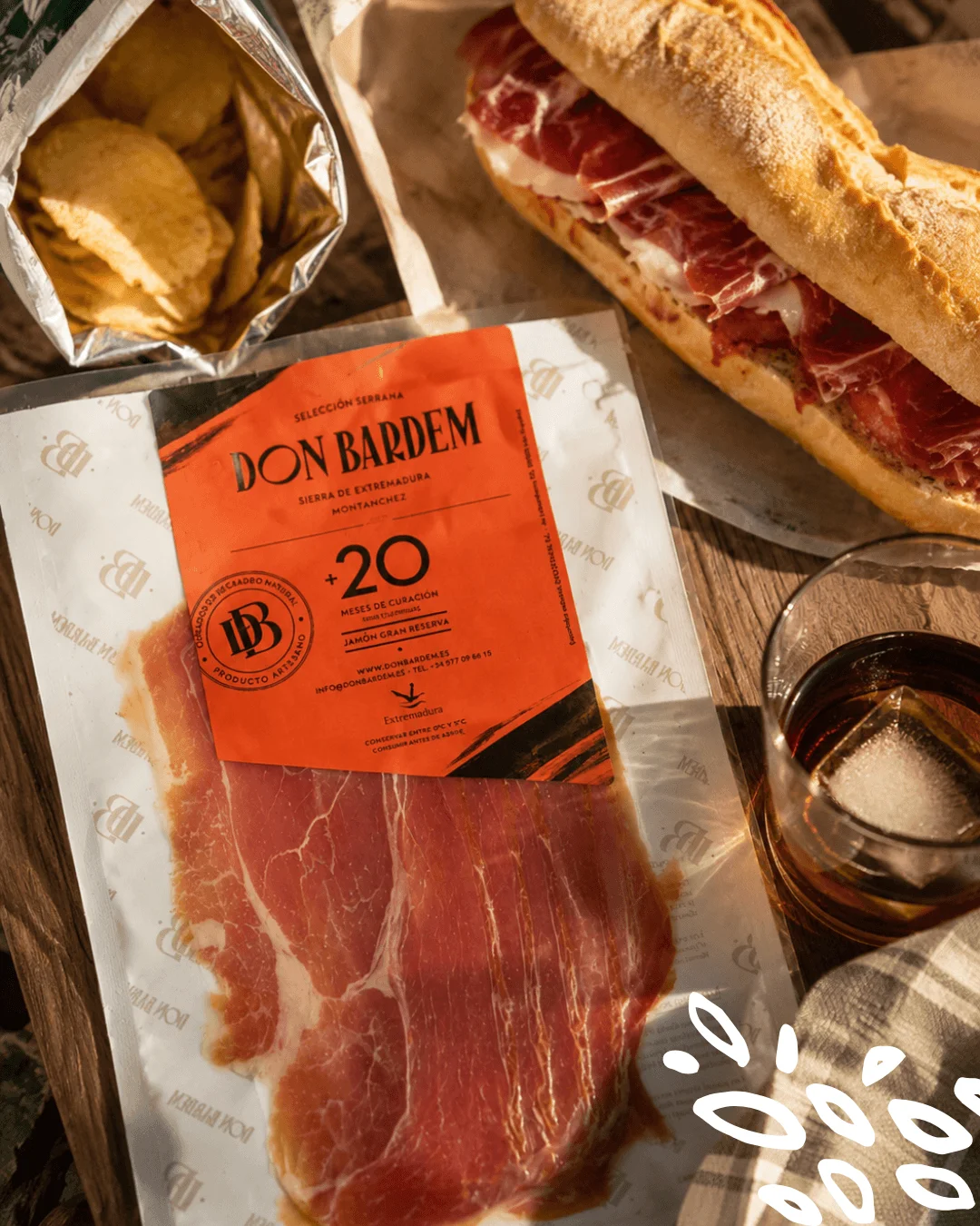 Serrano Gran Reserva Don Bardem prétranché, affiné plus de 20 mois à Montánchez, présenté avec un sandwich gourmet.
