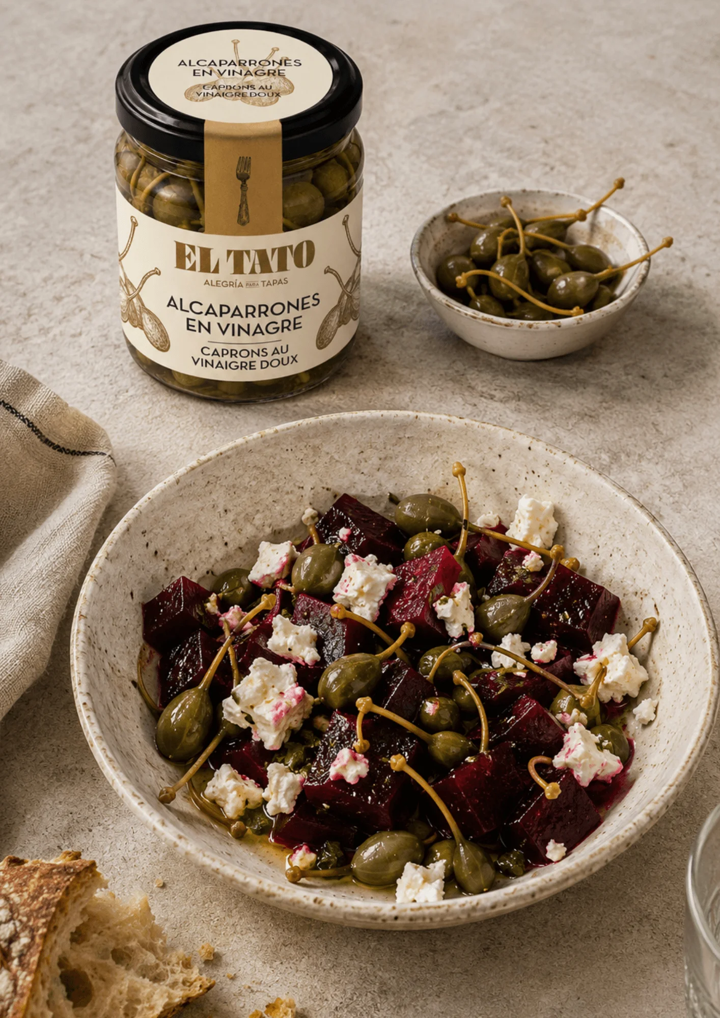 Bocal de câprons au vinaigre El Tato posé près d'un bol de câprons frais, avec au premier plan une salade de betterave rôtie, féta émiettée et alcaparrones