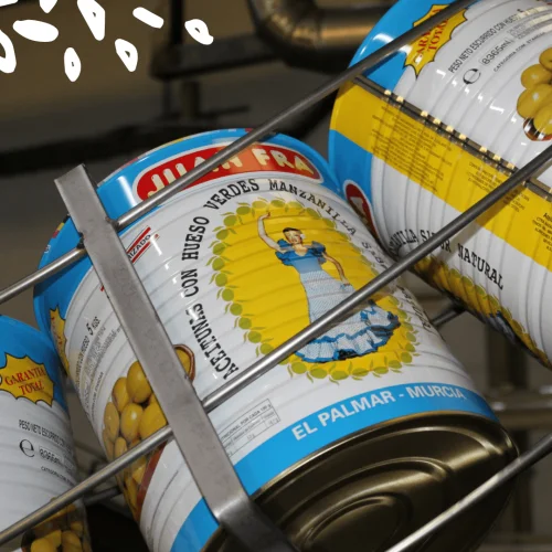 Boîtes de conserve d'olives Manzanilla Juan Fra empilées sur des étagères métalliques dans l'entrepôt d'El Palmar, Murcia